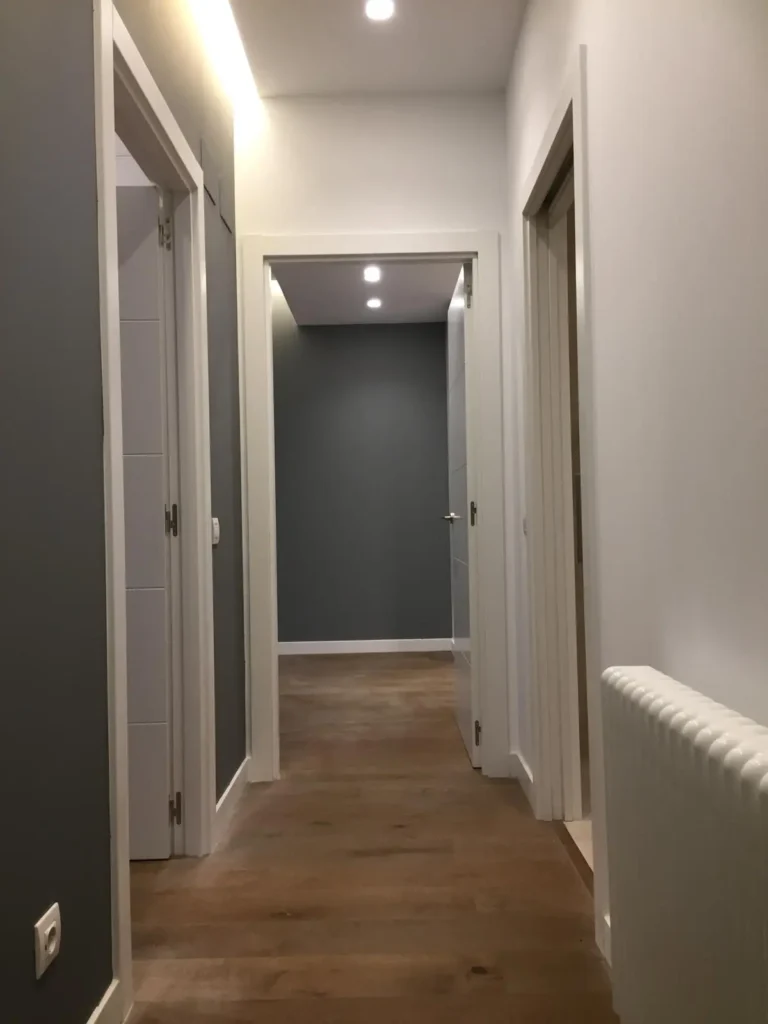 pasillo reformada con suelo de madera y paredes blanco-gris